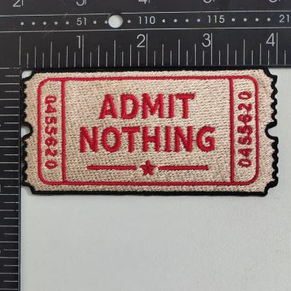 Patch with 'Admit Nothing' text on a ruler for size reference