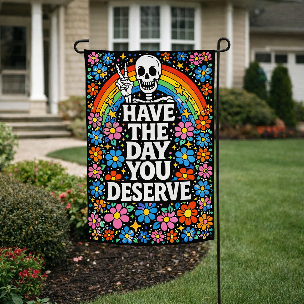 Colorful garden flag with a skeleton, rainbow, and flowers in front of a house.