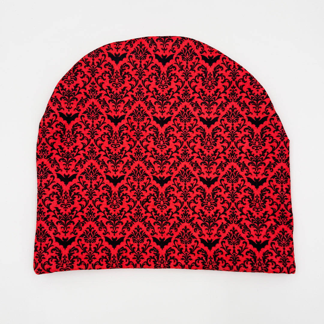 Red beanie with black floral pattern on a white background