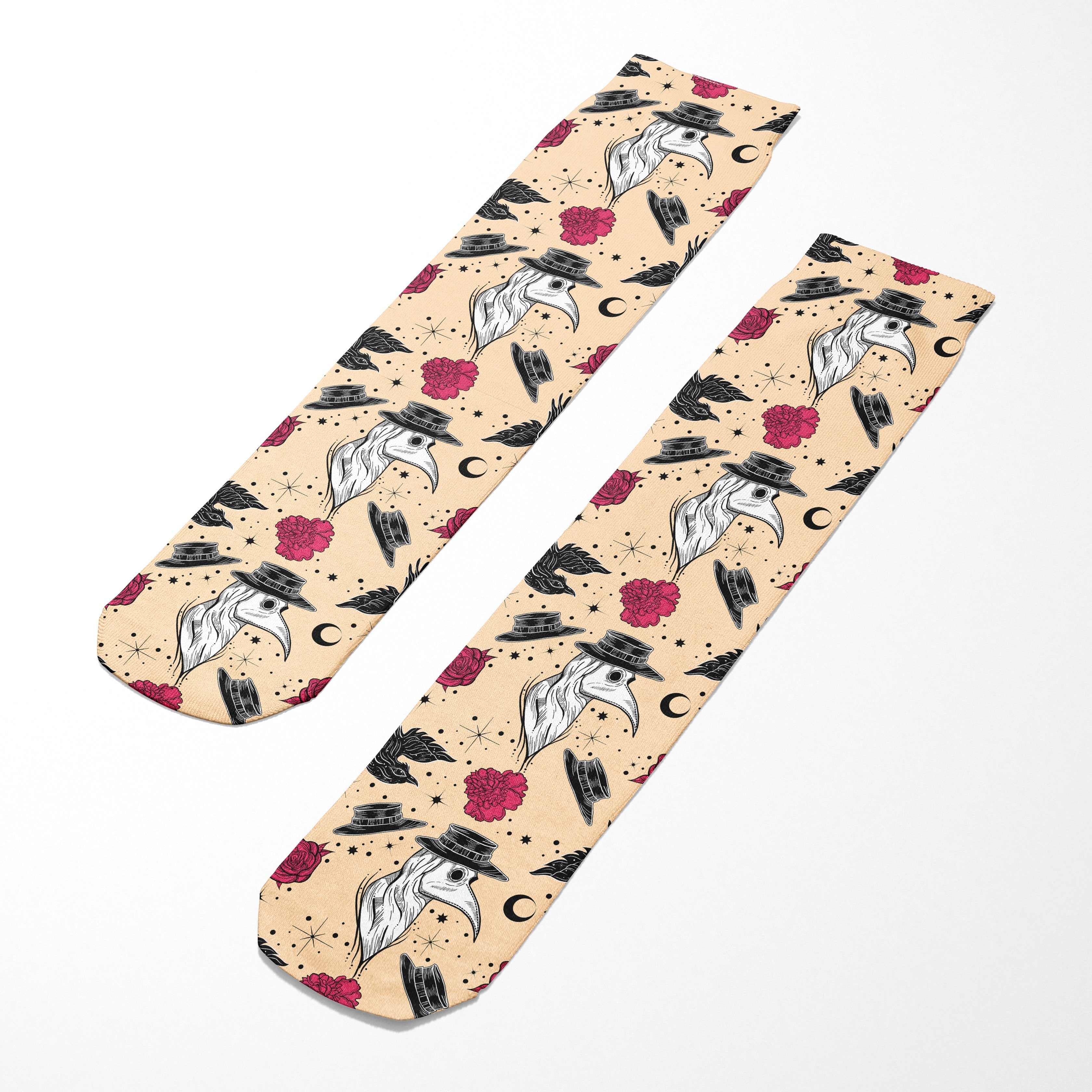 Two socks with a pattern of birds, hats, and flowers on a beige background.